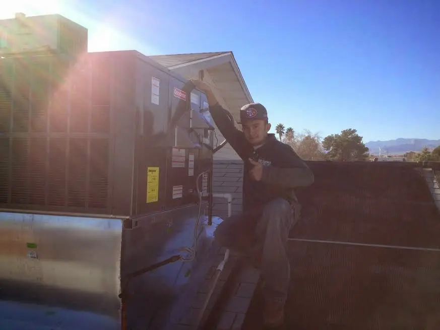 HVAC technician performing Heat Pump Repair on a rooftop unit in Anthem